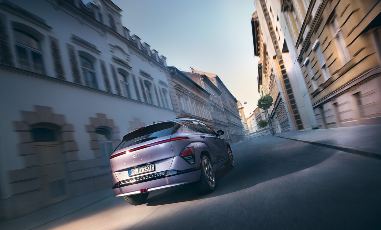 Hyundai Kona fährt durch durch eine Stadt Heckansicht.