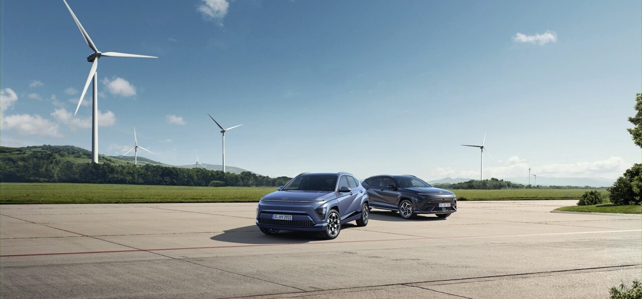 Hyundai Kona in der Natur vor einem Windrad.